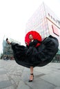 Fashion woman posing in center of Beijing. Young beautiful chinese girl outdoor wearing long black dress with high heels holding Royalty Free Stock Photo