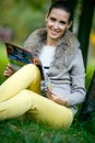 Fashion woman reading magazine outside in evening park Royalty Free Stock Photo
