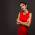 Fashion woman in red dress and bun hairstyle. Gold earrings. Dark background. Copycpase Royalty Free Stock Photo