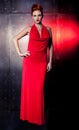 Fashion woman red dress with litle bag. Metal wall background Royalty Free Stock Photo