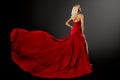 Fashion Woman in Red Dress with Long Train over Black. Sexy Blond Hair Girl in Evening Silk Gown Back Side View. Beautiful Model Royalty Free Stock Photo