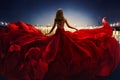 Fashion Woman in Red fluttering Dress Back Side Rear View. Glamour Model dancing with Long Silk Fabric flying on Wind over Night Royalty Free Stock Photo