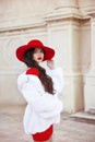 Fashion woman in red hat and dress wearing white fur coat. Elega Royalty Free Stock Photo