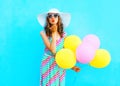 Fashion woman is sends an air kiss holds an air colorful balloons Royalty Free Stock Photo