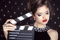 Fashion woman with red lips holding cinema clap. Super star