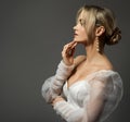 Fashion Woman Side view Portrait in White Dress over Dark Background. Beautiful Girl Face Profile with Bridal Hairstyle. Elegant Royalty Free Stock Photo