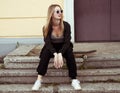 Fashion woman sitting on skateboard. Girl in sunglasses with longboard on stairs Royalty Free Stock Photo