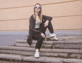 Fashion woman sitting on skateboard. Girl in sunglasses with longboard on stairs Royalty Free Stock Photo