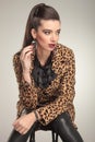 Fashion woman sitting on a stool, looking away Royalty Free Stock Photo