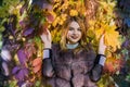 Fashion woman. Smiling girl in fur coat posin in autumn park with trees and ivy Royalty Free Stock Photo