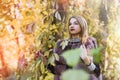 Fashion woman. Smiling girl in fur coat posin in autumn park with trees and ivy Royalty Free Stock Photo