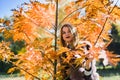 Fashion woman. Smiling girl in fur coat posin in autumn park with trees and ivy Royalty Free Stock Photo