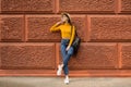 Fashion woman is standing near the orange wall. Royalty Free Stock Photo