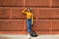 Fashion woman is standing near the orange wall. Royalty Free Stock Photo