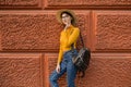 Fashion woman is standing near the orange wall. Royalty Free Stock Photo