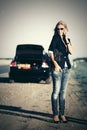 Fashion woman in sunglasses calling on phone next to broken car Royalty Free Stock Photo