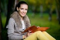 Fashion woman using a tablet computer outside in evening park Royalty Free Stock Photo