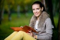 Fashion woman using a tablet computer outside in evening park Royalty Free Stock Photo