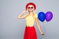 Fashion pretty woman with yellow air balloon over colorful gray background full height Royalty Free Stock Photo