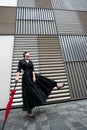Fashion woman. Young beautiful chinese girl posing over gray metal urban wall background. Stylish trendy lady wearing black dress Royalty Free Stock Photo