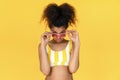 Fashion young african girl wear glasses look at camera isolated on yellow wall