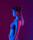 Fashion young girl profile side view stand on purple background, vertical. Royalty Free Stock Photo