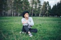 young man model in grey sweater rest sitting on grass in hat Royalty Free Stock Photo