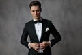 Fashion young man wearing black tuxedo and arranging coat Royalty Free Stock Photo