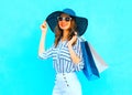 Fashion young smiling woman wearing a shopping bags, straw hat