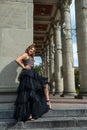 Fashion young woman full length in evening black dress walking in city daytime Royalty Free Stock Photo