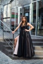 Fashion young woman full length in evening black dress walking in city daytime Royalty Free Stock Photo