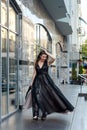 Fashion young woman full length in evening black dress walking in city daytime Royalty Free Stock Photo