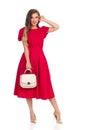 Fashion Young Woman In Red Dress, Gold High Heels And Beige Purse Royalty Free Stock Photo