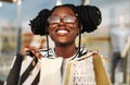 Fashionable African American woman in sunglasses, with shopping bags looking at a shop window in the city Royalty Free Stock Photo