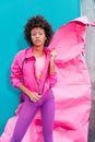 fashionable afro model posing in 80s style clothes on turquoise Royalty Free Stock Photo