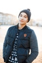 Fashionable American young man with a charming smile in a vintage stylish hat in a Christmas knitted sweater Royalty Free Stock Photo