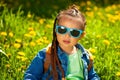 baby girl sitting in sunglasses in the grass on nature Royalty Free Stock Photo