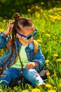baby girl sitting in sunglasses in the grass on nature Royalty Free Stock Photo