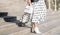 Fashionable bag close-up in female hands.Girl walks in the city outdoors. Stylish modern and feminine image, style. Royalty Free Stock Photo