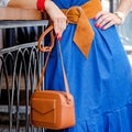 Fashionable bag close-up in female hands.Girl walks in the city outdoors. Stylish modern and feminine image, style. Royalty Free Stock Photo