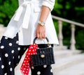 Fashionable bag close-up in female hands.Girl walks in the city outdoors. Stylish modern and feminine image, style. Royalty Free Stock Photo