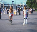 Fashionable beautiful girls on rollers and on a bicycle