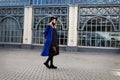 Fashionable beautiful woman walking on the street. Stylish trend in autumn or spring clothes is blue coat, felt hat Royalty Free Stock Photo