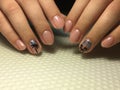 Fashionable beige manicure on short nails with foil and stamping design Royalty Free Stock Photo