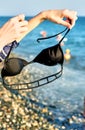 Black bra in the hands of a young girl on the beach