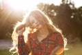 Fashionable blonde model in checkered dress posing in rays of sun Royalty Free Stock Photo