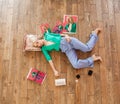 Fashionable blonde woman lying on the floor on pillow with cosmetics and magazines around her Royalty Free Stock Photo