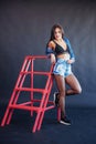 Fashionable brunette beautiful woman posing in studio wearing short jeans. Royalty Free Stock Photo