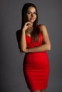 Fashionable brunette in red dress on grey background Royalty Free Stock Photo