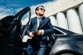 Low angle view of young businessman disembarking from car